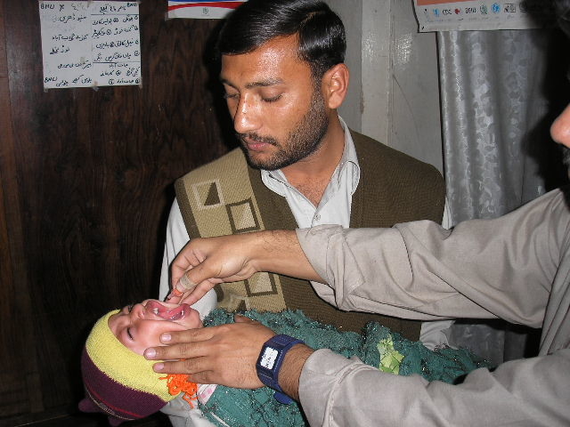 A child receives polio drops as a desperate struggle continues to contain the virus