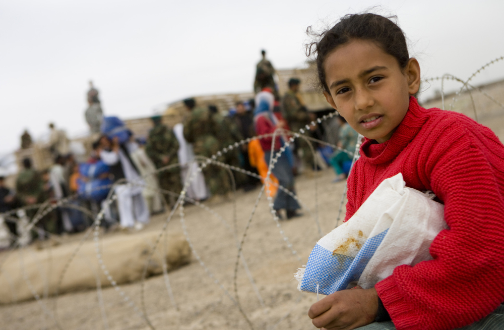 A young girl is watching over the distribution while she guards her own supplies until somebody comes to help her move it. The Humanitarian Aid operation was led by the Afghanistan National Army (ANA) While being over watched by the Americans