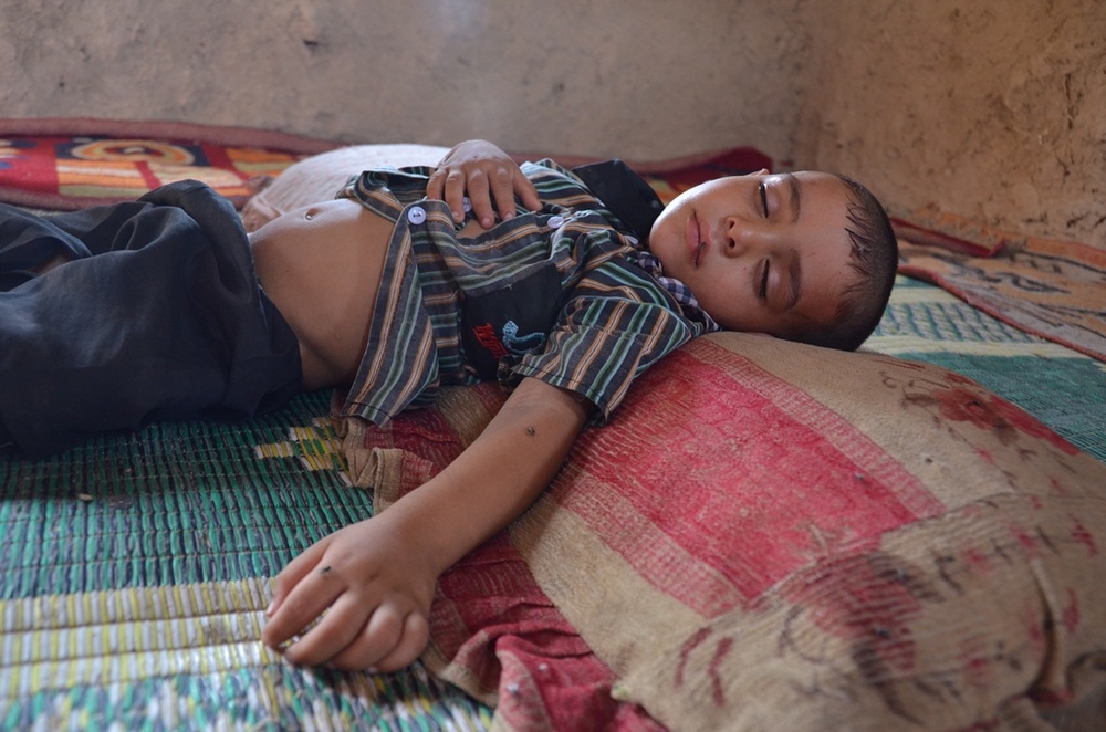 A child sleeps on the floor at al-Rustumiya settlement on the outskirts of the Iraqi capital Baghdad. He is sick but his family cannot afford healthcare. More than 100 families - displaced first by Saddam Hussein's de-Arabization policies, then by Iraq's 