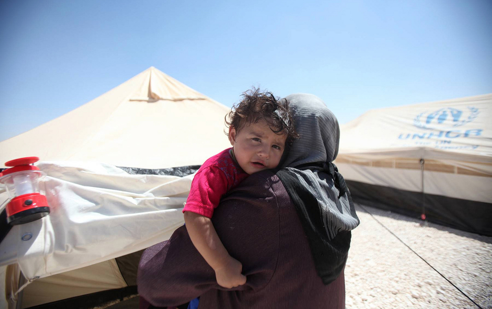 A Syrian refugee woman holds her child in Jordan's Zaátri camp
