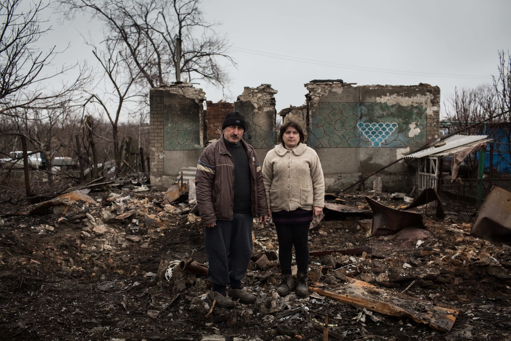 Yurvi and Tatiana stand in the ruins of their home in Nikishino, eastern Ukraine. The couple's home was hit during fighting in the village and was completely destroyed.