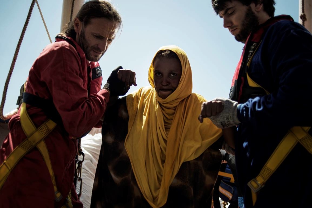 A pregnant Somali woman is helped onto the MSF boat, Dignity 1, after being rescued at the sea on August 23, 2015