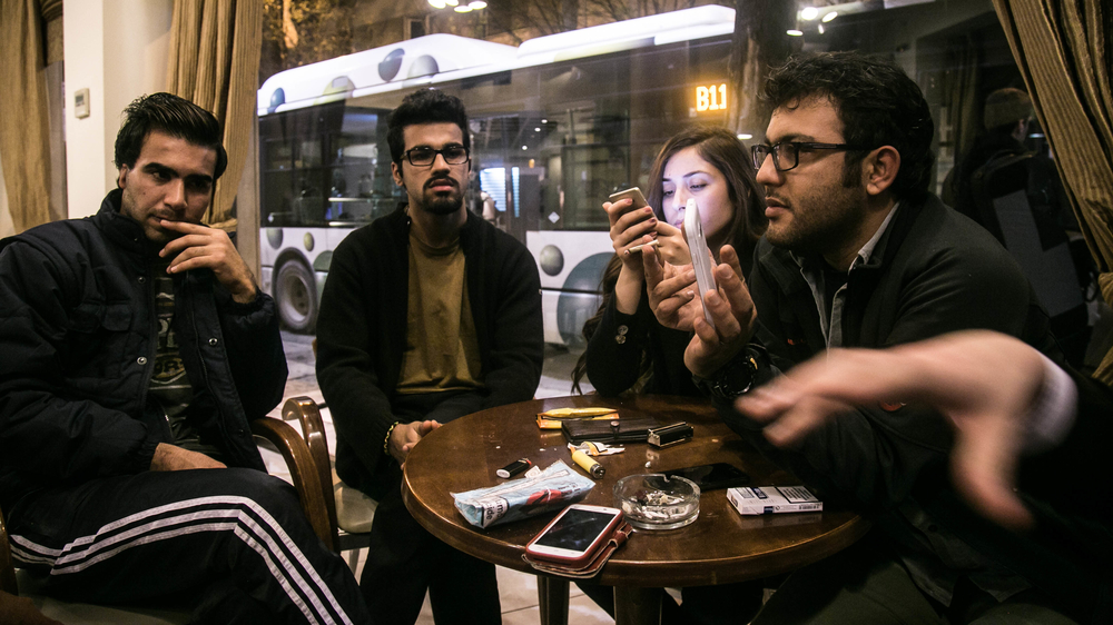 Aral Kakl, a Kurdish Iraqi journalist, his Syrian wife Shevin, his brother Rewan and some other refugees who have applied for the relocation programme, kill time in the cafeteria of their Athens hotel 