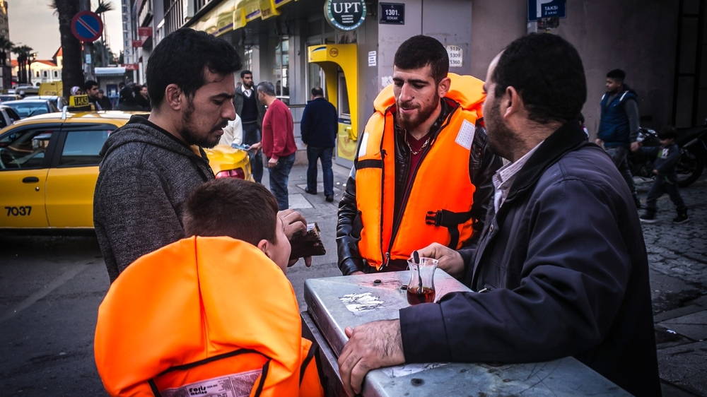 Les passeurs turcs s’adaptent et prospèrent A Syrian refugee buys lifejackets in the streets of Basmane