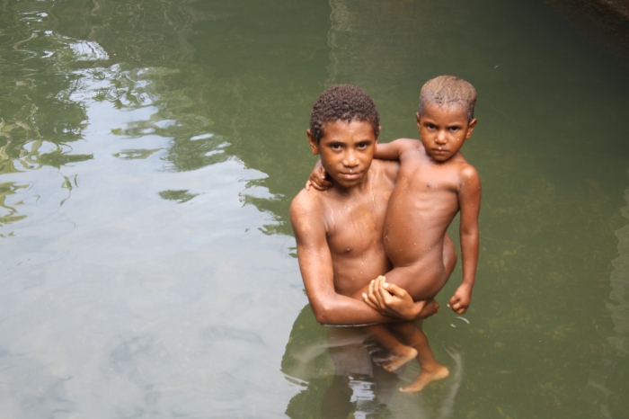 Two boys bathing in a river outside Madang, Papua New