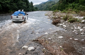 Aid workers with ACTED cross a river during a cholera response mission. Les Cayes, Haiti. (November 2013)