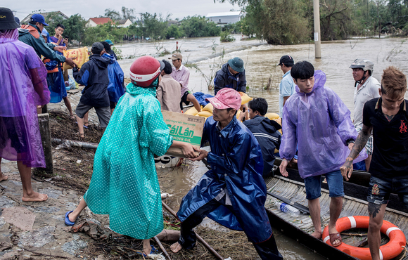Volunteers deliver aid packages to residents affected by heavy floods in Quang An commune, in Thua Thien Hue, Vietnam, on 20 October 2020.
