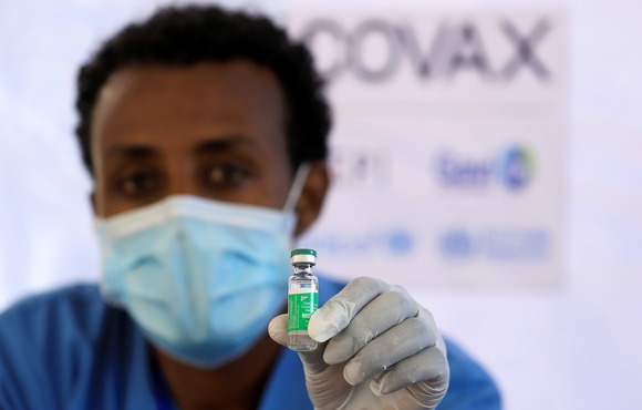 A nurse displays the AstraZeneca/Oxford vaccine.