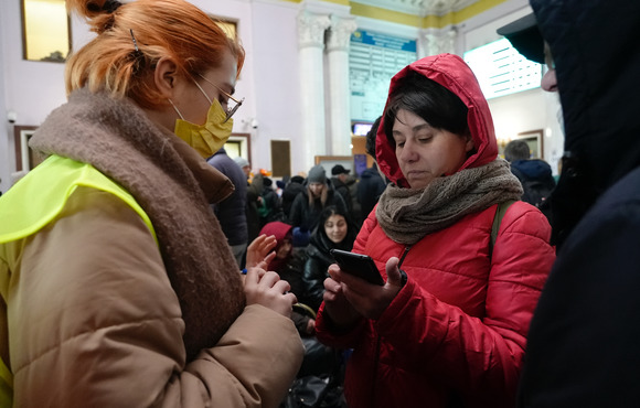 A volunteer helping a woman at the train station in Lviv.