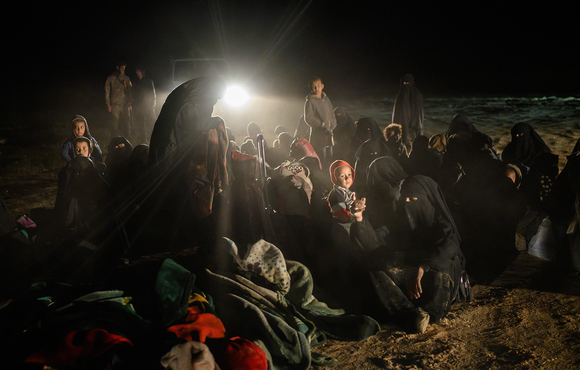 Kurdish fighters check wives and relatives of members of the so-called Islamic State