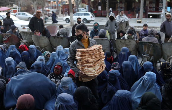 A man distributes bread at a market in Kabul, Afghanistan, on 31 January 2022. Drought and a crumbling economy are driving rising hunger. 