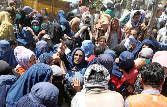 A group of people crowd around the outside of a tent