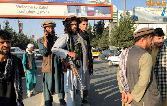 A Taliban member stands outside Hamid Karzai International Airport in Kabul, Afghanistan, on 16 August 2021. The speed of the Taliban’s advance on the capital took aid agencies by surprise. 