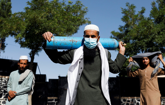 A man waits to refill his oxygen cylinder during Afghanistan’s third COVID-19 wave in June. Donor funding freezes after the Taliban takeover will severely disrupt coronavirus treatment and vaccination, health officials say