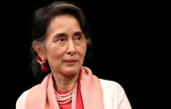 A portrait image of Aung San Suu Kyi against a black backdrop.