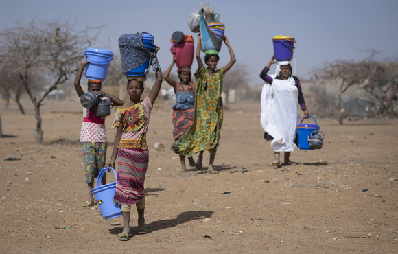 Malian refugees carry new dignity kits in Goudoubo camp in Burkina Faso