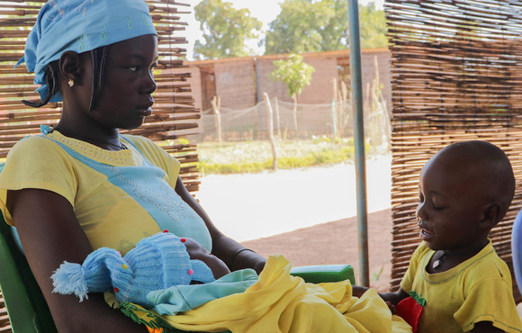 Sibri Natana sits at a restaurant in Fada N'gourma with two of her children. 
