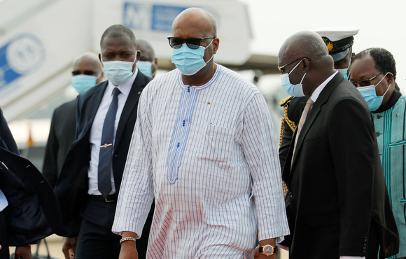 A photo shows Burkina Faso's President, Roch Kabore, walking with a face mask. Burkina Faso’s leader, Roch Kaboré, is one of 13 candidates running in upcoming presidential and parliamentary elections that could face disruption by extremist groups. 