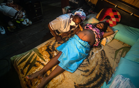 Juana del Carmen Martínez, a traditional midwife, assists an Indigenous mother, Elina Chamorro, by listening to her stomach as she lies on a bed, in Quibdó, Colombia, 29 November 2020.