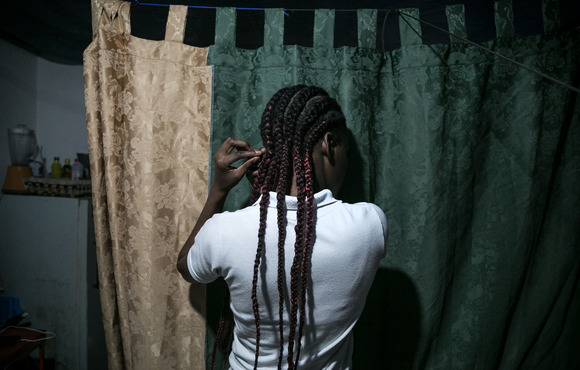 A photo of a girl facing away from the camera named *Marta, who has been unable to obtain refugee status in Ecuador and therefore must rely on her mother for support. 