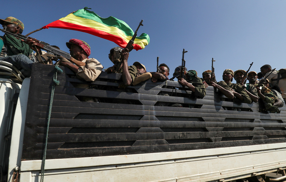 Militia fighters ride to the frontline to face troops from the Tigray People's Liberation Front. A week of air raids and clashes in northern Ethiopia has left hundreds dead and thousands displaced