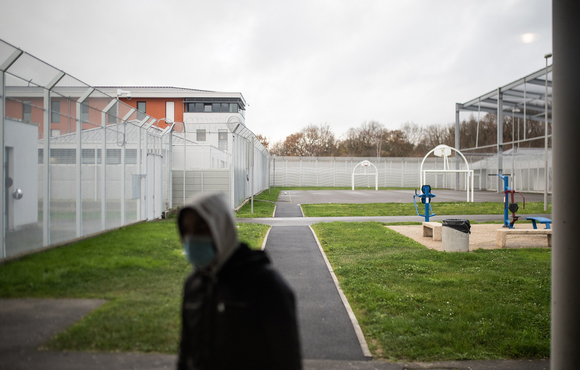 A young man stands in the courtyard of a centre near the French city of Rennes where migrants are detained before they are deported