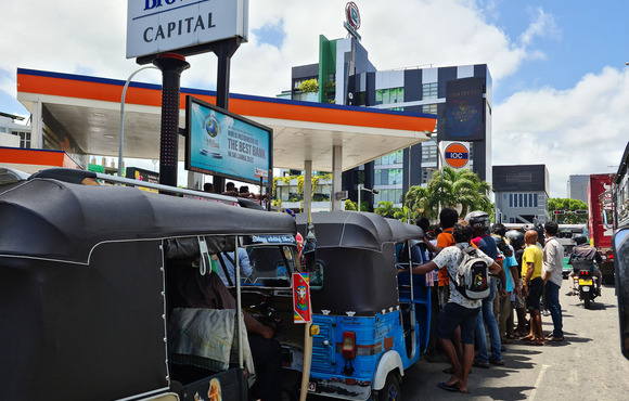 Tuk tuk and motorcycle drivers wait in a fuel queue in the Sri Lankan capital, Colombo. Lines for petrol and cooking gas can last for days.