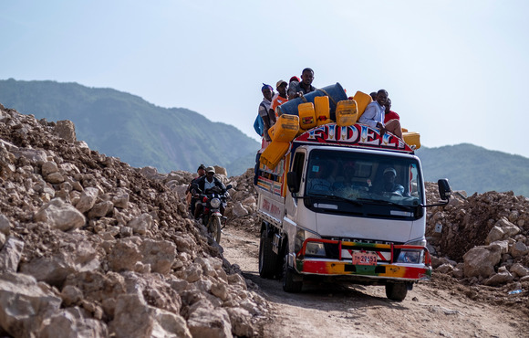 People ride on a bus through a road partially blocked by rocks from a landslide near Pestel, Haiti, after a 7.2 magnitude earthquake took place on 14 August. 