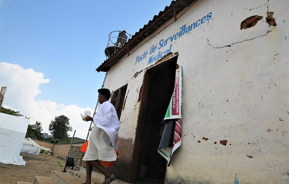 A health technician prepares a hand washing device in Rumonge