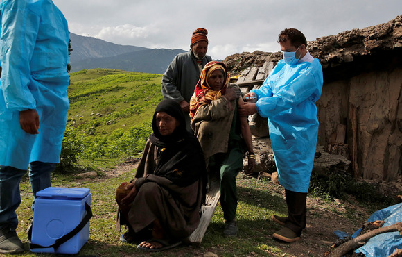 A woman receives a COVID-19 vaccine dose during a vaccination drive in the Kashmir valley’s Budgam district on 21 June, 2021.