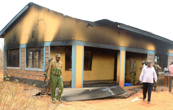 Security officers and residents assess the damage at a teacher's house in Mandera county