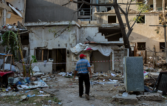 A man looks at the remains of his home after it was damaged in the 4 August explosion at Beirut's port.