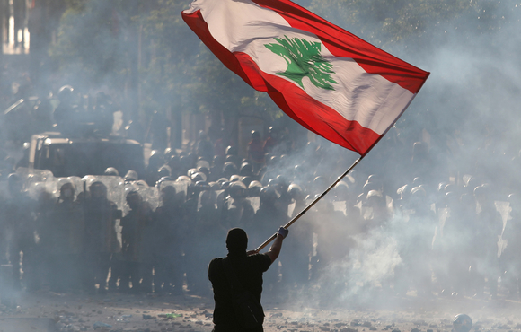 A demonstrator waves the Lebanese flag
