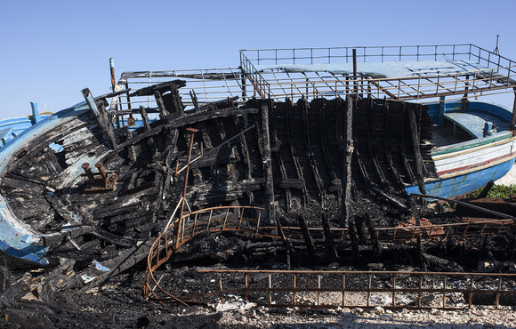 The burnt-out wreck of the Portopalo di Capo Passero, a ship used by migrants to cross the Mediterranean, is kept in the Mazara del Vallo port after being confiscated by Italian police.