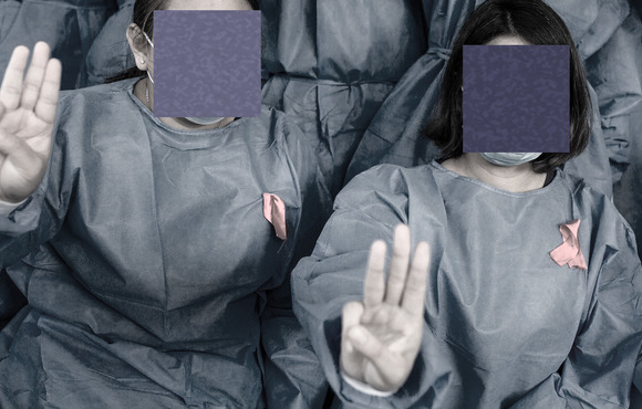 Medical staff wearing red ribbon tags raised the three finger salutes in protest against Myanmar's military coup in February 2021.