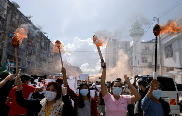 A group of women hold torches as they protest against the military coup in Yangon, Myanmar on 14 July, 2021.