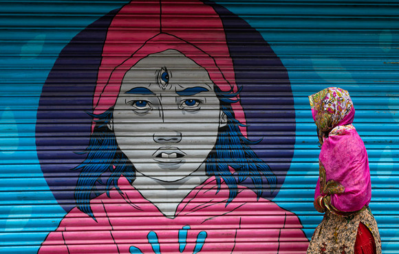 A woman covers her face with a shawl as she waits for relief goods to be distributed near a community centre during coronavirus movement restrictions in Kathmandu on 4 June 2021.