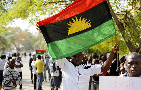 The flag of the defeated breakaway republic of Biafra is held by a protester demanding secession once again for southeastern Nigeria