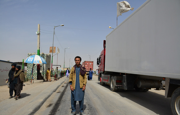 A man stands in front of Abrisham bridge waiting to cross.