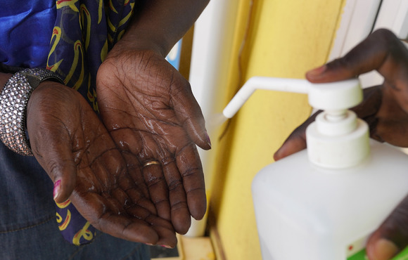 A woman has her hands sprayed with hand sanitiser at a supermarket in Juba, South Sudan, 1 April, 2021