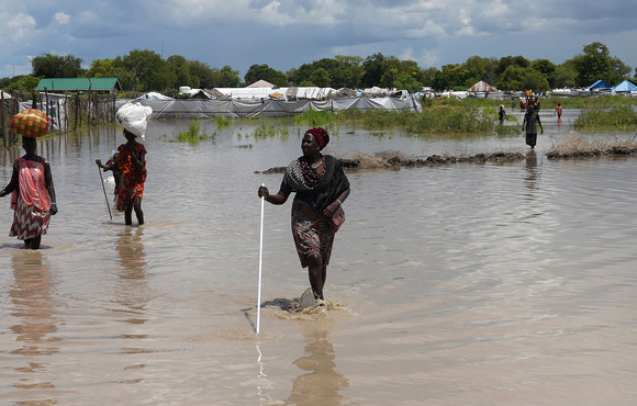 Women wade through floodwaters after the River Nile broke through flood defences in Pibor, South Sudan, 6 October 2020. 