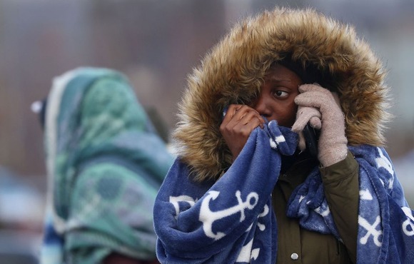 A West African woman in tears as she talks on the phone at the Polish border after fleeing Ukraine