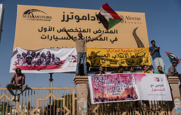 A protester holds a Sudanese flag during a march through the streets of Khartoum’s Buri neighbourhood, 17 November 2021.