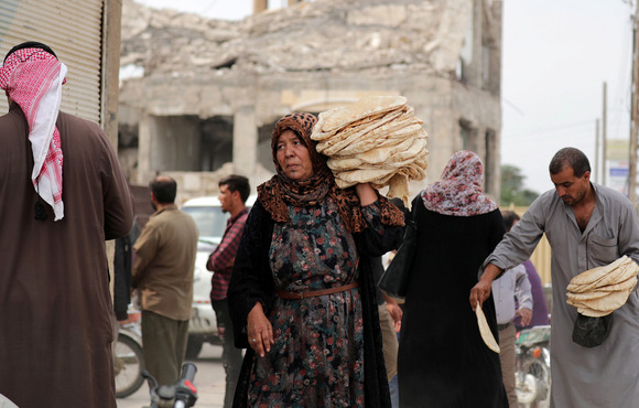 A woman carries bread in Tel Abyad, a town in northern Syria, on 16 October 2019.