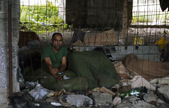 An asylum seeker from Pakistan sits in the abandoned building near the Trieste railway station that has become a makeshift shelter