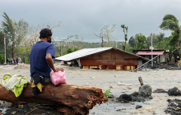 A man looks at his house buried under the pile of rubble and sand following flash floods brought by Typhoon Goni in Barangay Busay, Daraga town, Albay province, Philippines on 1 November, 2020. 