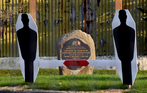 Signs outline the distance of 2 metres apart in front of a linked fence. 