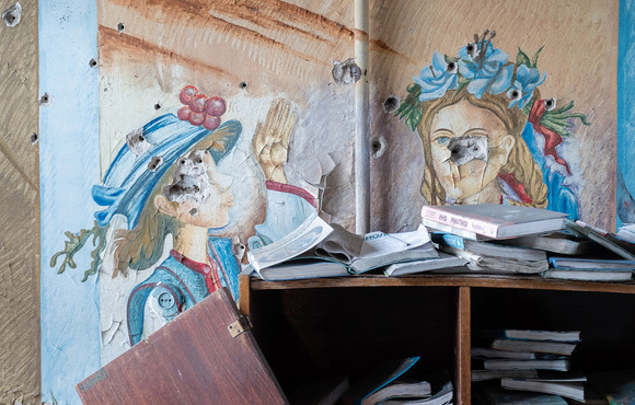 A school library in the village of Opytne. Soldiers have been training on the paintings of the children, leaving their faces marked with bullet holes.