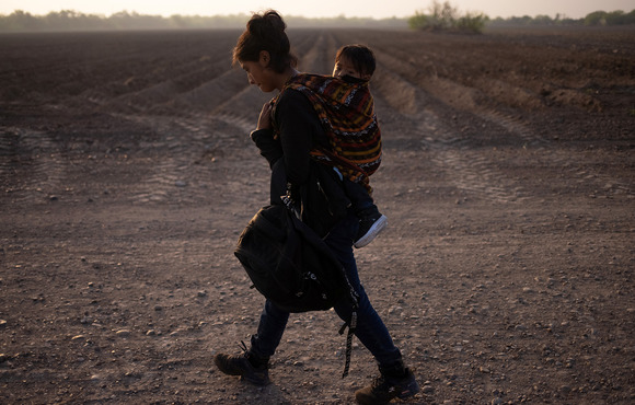 Mayra, a 17-year-old asylum seeking mother from Guatemala, carries her 13-month-old son Marvin after they crossed the Rio Grande river into the United States from Mexico on a raft, 17 March 2021.