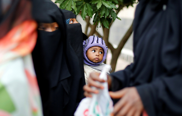 A woman from the Muhamasheen community holds her son at a charity clinic in Sanaa